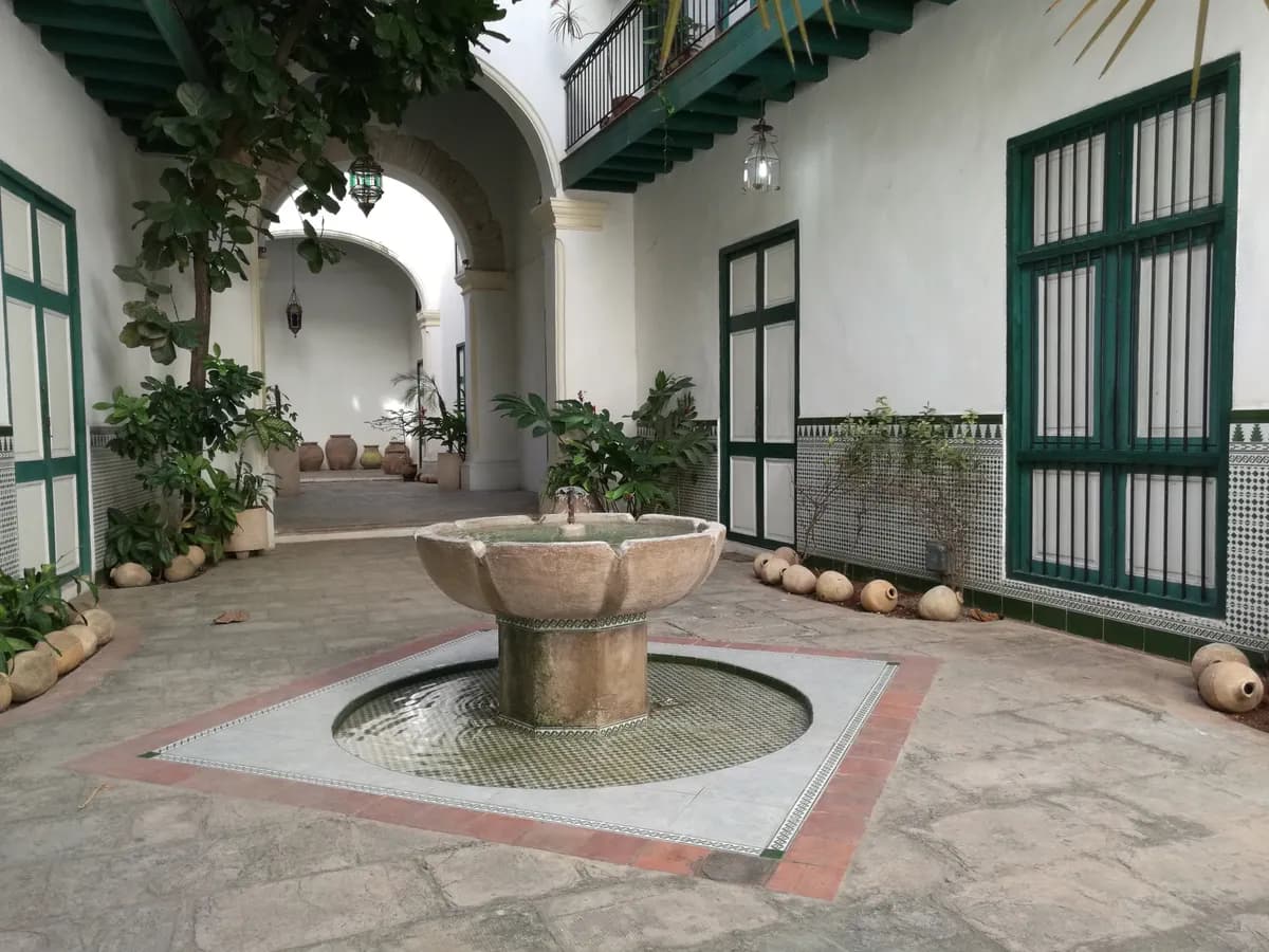 BookNoFees example image: Cuban courtyard with a fountain and green-painted doors