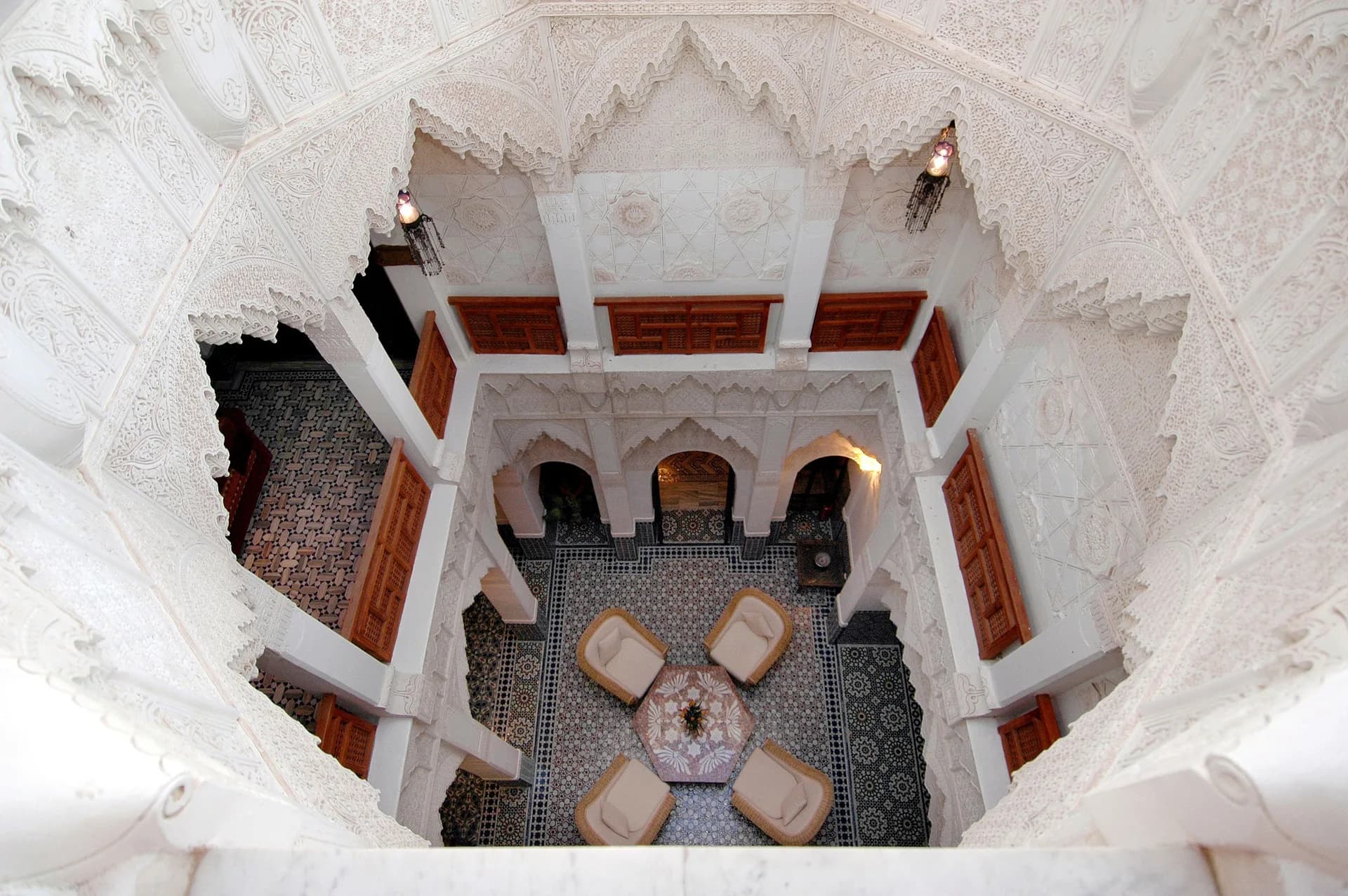 BookNoFees sample image: A bird’s-eye view of a riad courtyard with ornate arches and seating areas