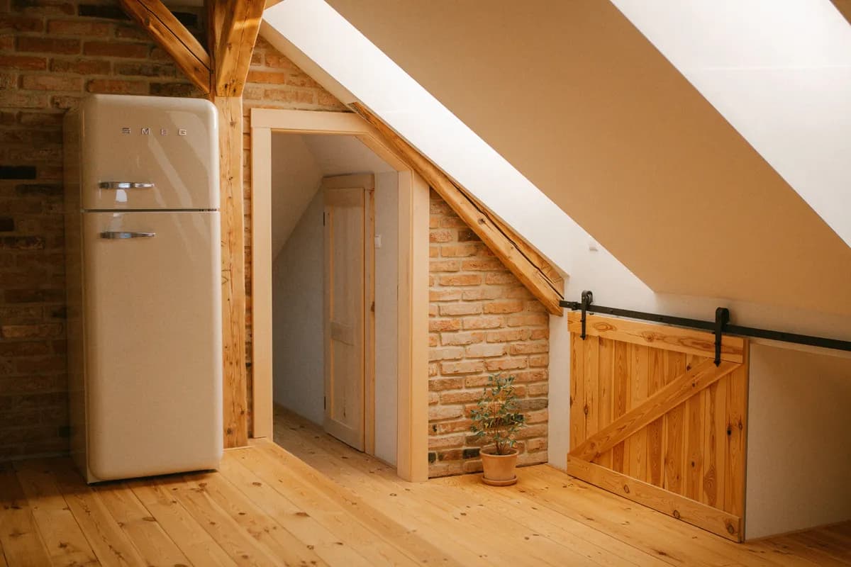 BookNoFees Sample Image: Converted attic with wooden beams, brick walls, and a low door