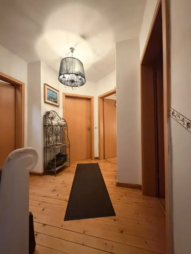 BookNoFees: homestay di Sundern, North Rhine-Westphalia, Jerman – Ruang lalu dengan lantai kayu, candelier, dan unit rak logam
