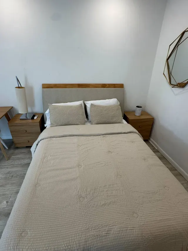 BookNoFees: homestay di Cutler Bay – Bilik tidur dengan katil double, meja sisi kayu, dan cermin dinding geometri