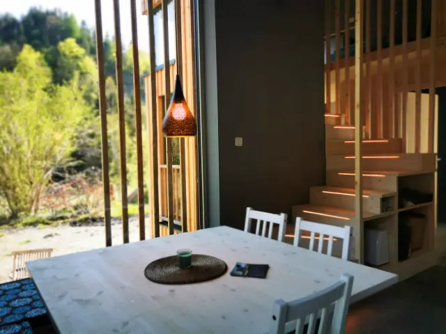BookNoFees: homestay di Hieflau, Styria, Austria – Ruang makan dengan meja putih, lampu gantung, dan tangga kayu dengan pencahayaan