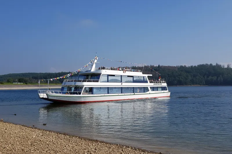 The passenger boat MS Sorpesee on the lake near Sundern, with forest on the far shore