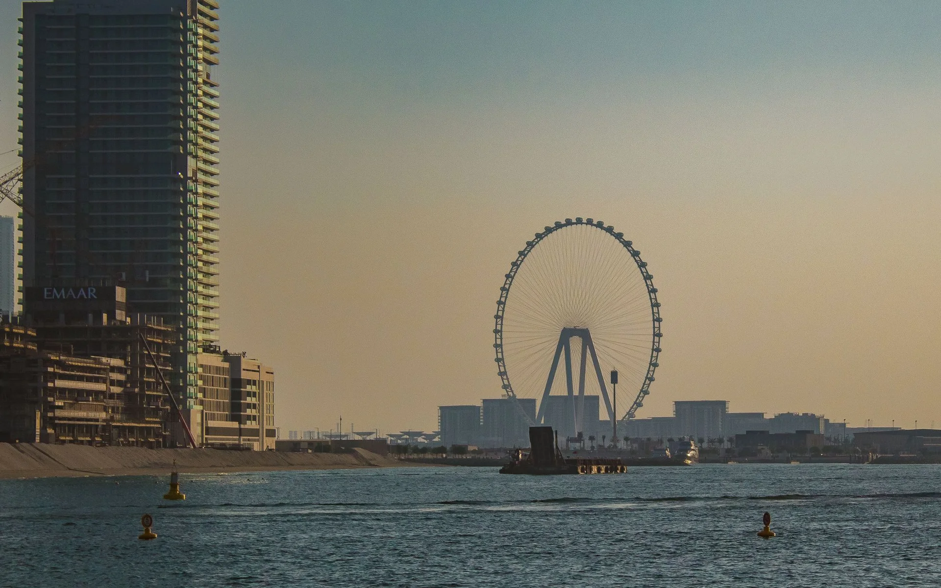 Garis langit Dubai dengan roda Ferris pada waktu matahari terbenam