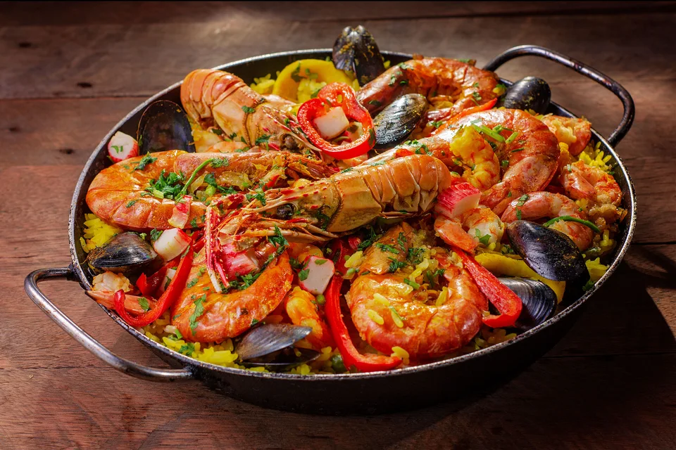BookNoFees: Contoh foto: Sebuah loyang paella makanan laut yang di atasnya diletakkan kerang dan lada merah